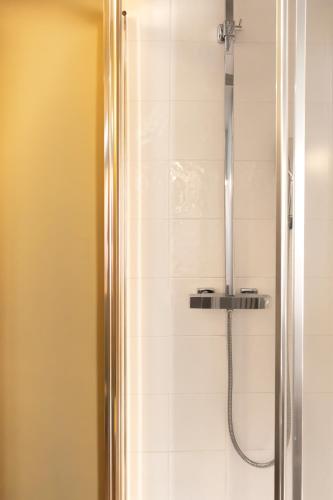 a bathroom with a shower with a glass door at Hotel Linette in Aumont-Aubrac
