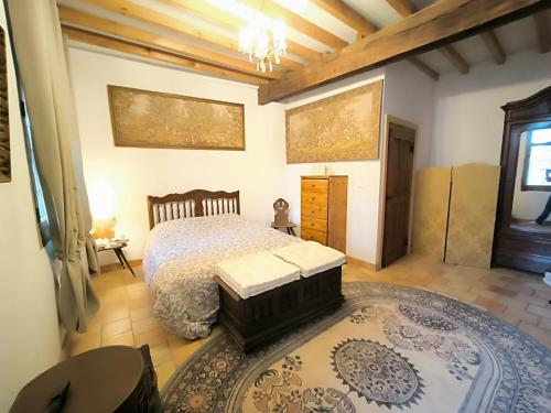 a bedroom with a bed and a large rug at La Toscane Médiévale in Saramon
