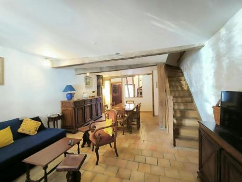 a living room with a blue couch and a dining room at La Toscane Médiévale in Saramon