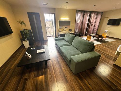 a living room with a green couch and a table at LiVEMAX RESORT Kinugawa in Nikko