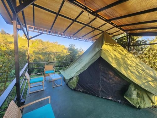 a tent on a balcony with two chairs at Ararat Eco Farm in Coto Brus