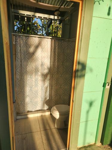 a bathroom with a toilet inside of a house at Ararat Eco Farm in Coto Brus
