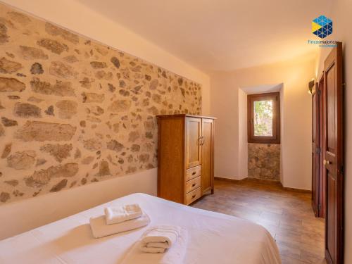 a bedroom with a bed and a stone wall at La Caseta de Lola in El Port de la Selva