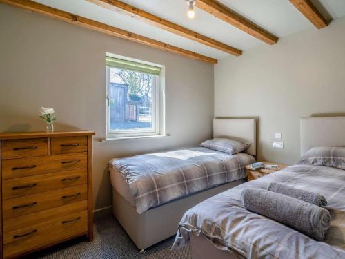 a bedroom with two beds and a dresser and a window at 2 Bed in Lancaster oc-82857 in Beetham