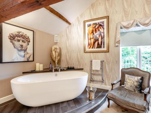 a large white tub in a bathroom with a chair at 4 Bed in Leyburn oc-83260 in Middleham