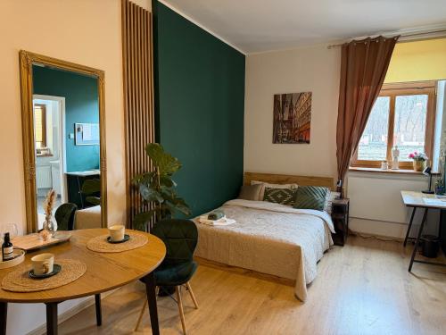 a bedroom with a bed and a table and chairs at Pod Aniołami in Wałbrzych
