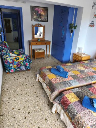a bedroom with two beds and a blue door at Studio By The Beach 2 in Saronida