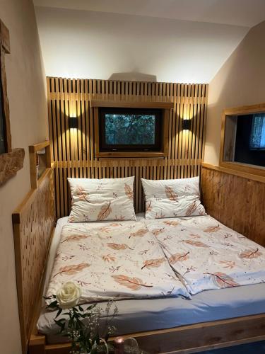a bed with a wooden headboard in a bedroom at Srub u Krále in Dobruška