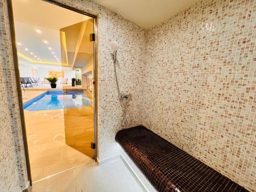 a bathroom with a shower and a swimming pool at ArdoVel Park Hotel in Velingrad