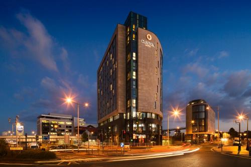 a tall building with a sign on it at night at Clayton Hotel Cardiff in Cardiff