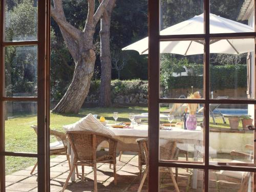 a table with a white umbrella and some chairs at El Jardí de Tamariu in Tamariu