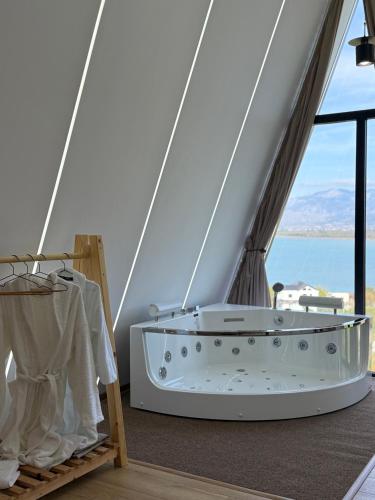 a bath tub in a room with a view of the ocean at Lakeside Villas & Jacuzzi Suites in Shirokë