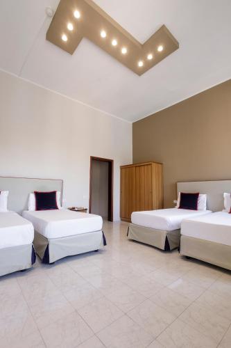 a room with three beds in a room at Hotel Santa Marta in Pozzuoli