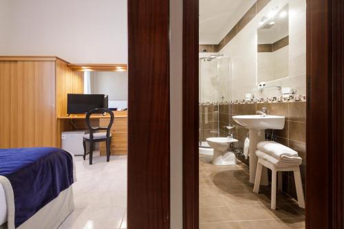 a bedroom with a bathroom with a sink and a toilet at Hotel Santa Marta in Pozzuoli