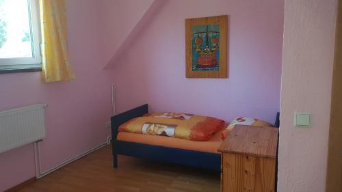 a small bedroom with a bed and a table at Ferienreihenhäuser Roswitha in Frauenberg