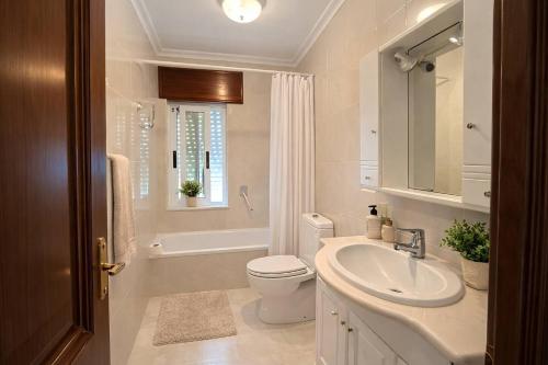 a bathroom with a sink and a toilet and a tub at Isa Rooms Sarria in Sarria