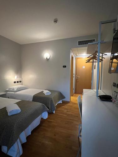 a hotel room with two beds and a counter at Master Hotel in Cadelbosco di Sopra