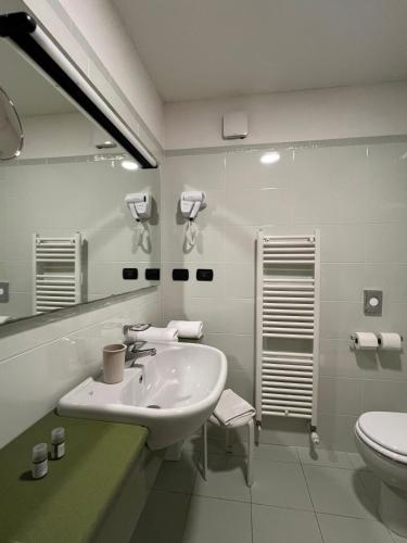 a white bathroom with a sink and a toilet at Master Hotel in Cadelbosco di Sopra