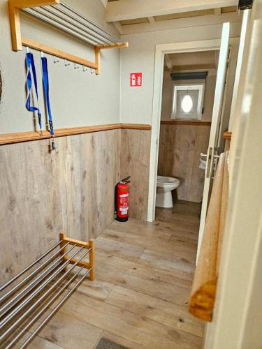 a bathroom with a toilet and a fire extinguisher at Duinenhuis Zeepolder 27 in De Haan