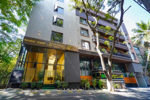 a building with a tree in front of it at Raayara Suites in Bangalore