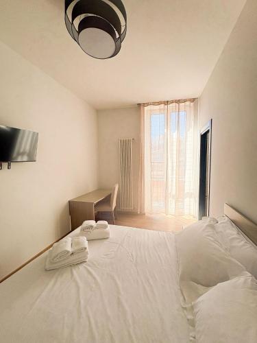 a bedroom with a white bed with two towels on it at Le Tre Lune Rooms in Matera