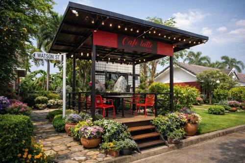 a restaurant with a table and chairs and flowers at The Room Suphanburi in Ban Nong Chaeng