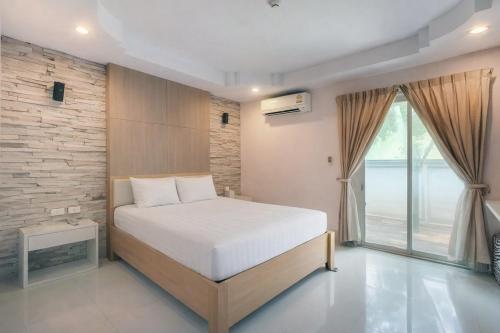 a bedroom with a white bed and a large window at The Room Suphanburi in Ban Nong Chaeng