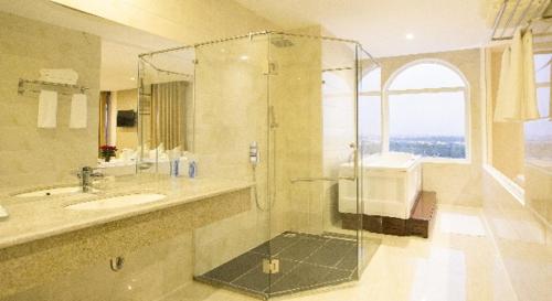 a bathroom with a glass shower and a sink at West Hotel in Can Tho