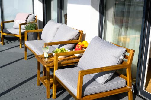 a pair of chairs and a table on a balcony at Miamare Dziwnow - Komfort Apartment, Panorama, Beach, Pool & Wellness in Dziwnów