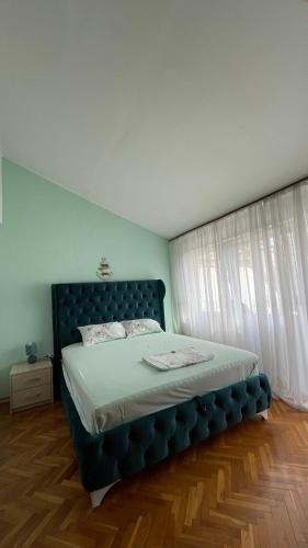 a bedroom with a bed with a blue headboard at Golden Grape House in Budva