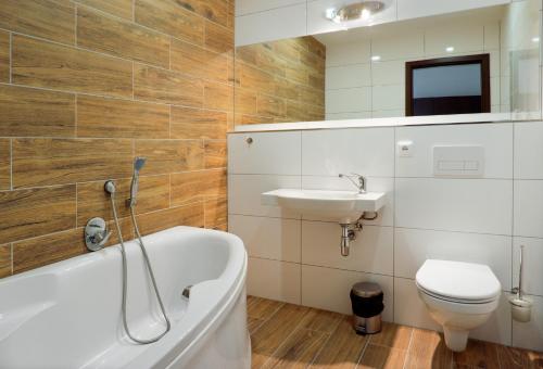 a bathroom with a tub and a sink and a toilet at Hotel ZRUČ in Zruč nad Sázavou