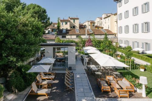 an outdoor patio with tables and chairs and umbrellas at Palazzo Castri 1874 Spa & Garden in Florence