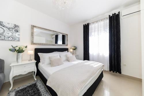 a white bedroom with a bed and a mirror at Central Square Luxury Boutique in Zadar