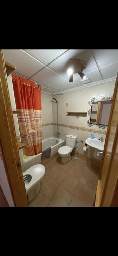 a bathroom with two toilets and a sink and a tub at Casa Enrique in Alicante
