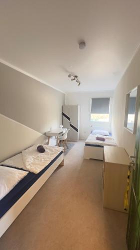 a bedroom with two beds and a desk in it at Jugendgästehaus Lichterfelde JuLi in Berlin