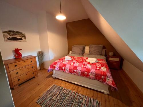 a bedroom with a bed and a dresser in a attic at Kreativ-Kate in Kranenburg