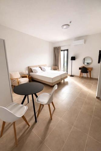 a bedroom with a bed and a table and chairs at CONSTA Luxury Apartments in Paralio Astros