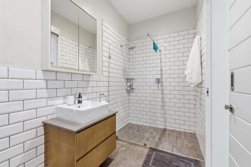 a white bathroom with a sink and a shower at Octopus Room in Ballito