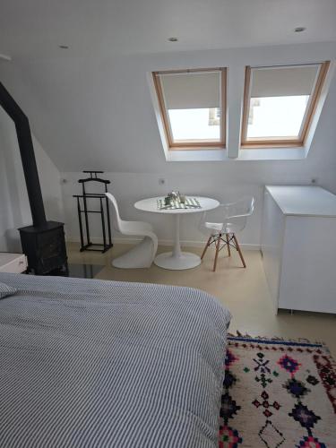 a bedroom with a bed and a table in a room at Studio Les 4 Vents in Tréffiagat