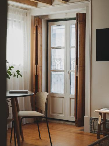 a room with a door and a table and chairs at Casa Solayme Vitória in Lisbon