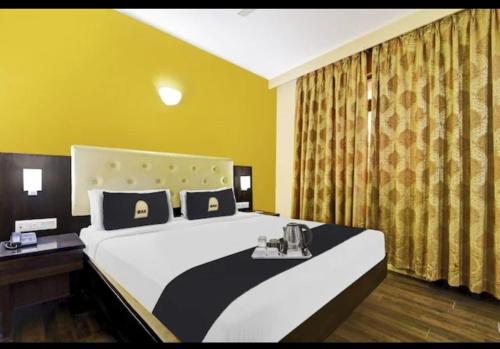 a bedroom with a large bed and a yellow wall at Hotel The Pal Palace in Nagpur