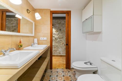 a bathroom with two sinks and a toilet at Casa con patio, piedra y luz natural in Sant Pere de Ribes