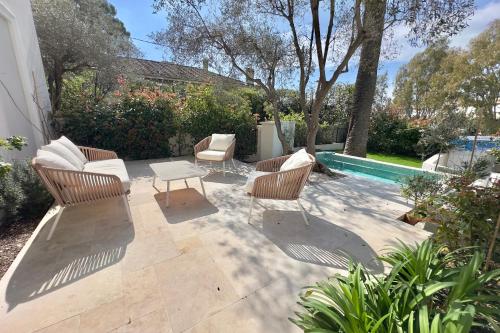 a patio with chairs and a table and a pool at Exclusive Villa Magnolia Apartment with Private Pool Cannes Center in Cannes