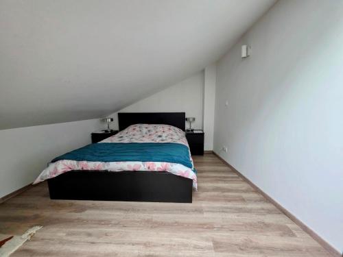 a bedroom with a bed and a wooden floor at Duplex Cosy proche parlement européen et Strasbourg in Schiltigheim