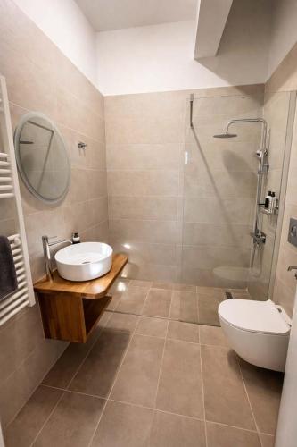 a bathroom with a sink and a shower and a toilet at CONSTA Luxury Apartments in Paralio Astros