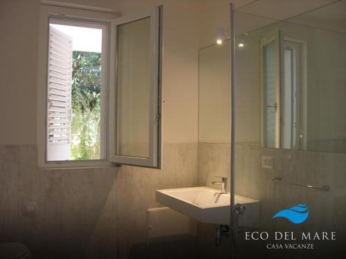 bagno con lavandino e specchio di Eco del Mare a Savelletri