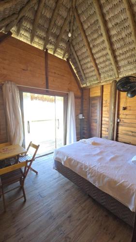 a bedroom with a large bed and a large window at Chalé mirante in Tutóia