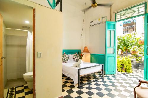 a bedroom with a bed and a bathroom with a toilet at Casa La Bella Samaria Boutique in Santa Marta