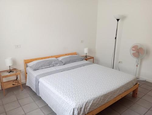a bedroom with a bed and two lamps and a fan at Casa Mirabella in Sirolo