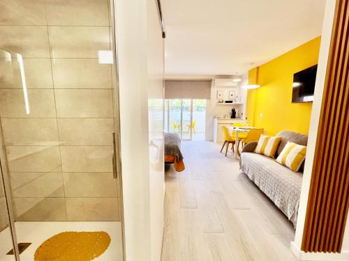 a living room with yellow walls and a sliding glass door at Modern Studio with Pool & Terrace Playa de las Américas, Tenerife in Playa de las Americas